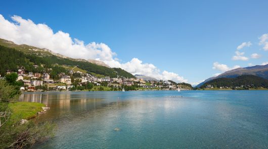 Sankt Moritz town and lake with transparent water in a sunny summer day in Switzerland